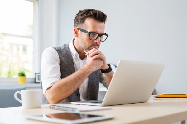 Man in glasses working on laptop from home Man in glasses working on laptop from home